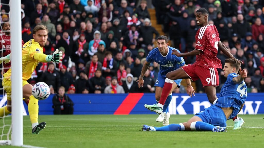 Liverpool striker Alexander Isak shoots past Brighton defenders and goalkeeper at Anfield during Liverpool's 2-0 win