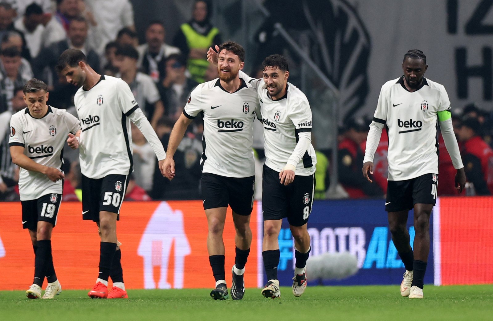 Beşiktaş players in white kits celebrating a goal against Crystal Palace in the Europa League in Istanbul