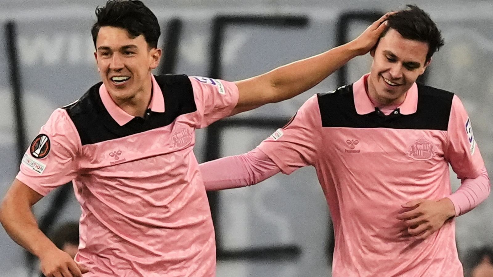 Two Sunderland players in pink away kits celebrating the opening goal against Lech Poznań in the Europa League