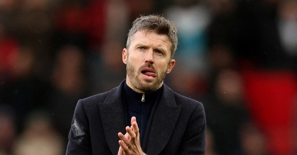 Manchester United head coach Michael Carrick, in a dark coat, applauds the fans at Old Trafford after the defeat by Bournemouth
