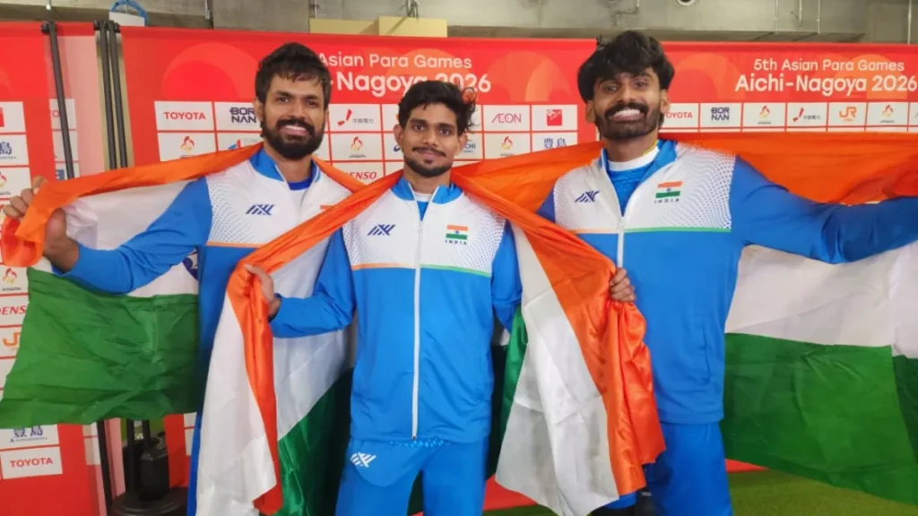 Indian high jumpers Shailesh Kumar, Varun Bhati and Rahul hold the Indian flag in front of the Asian Para Games Aichi-Nagoya 2026 backdrop after sweeping the men's T63 high jump medals