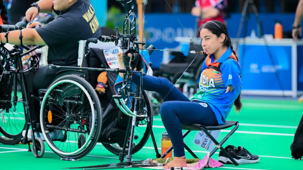 India's Sheetal Devi seated on the archery range in India team kit during a compound archery competition
